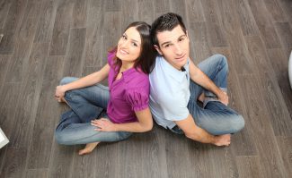 Couple Sat Back To Back On Laminate Flooring